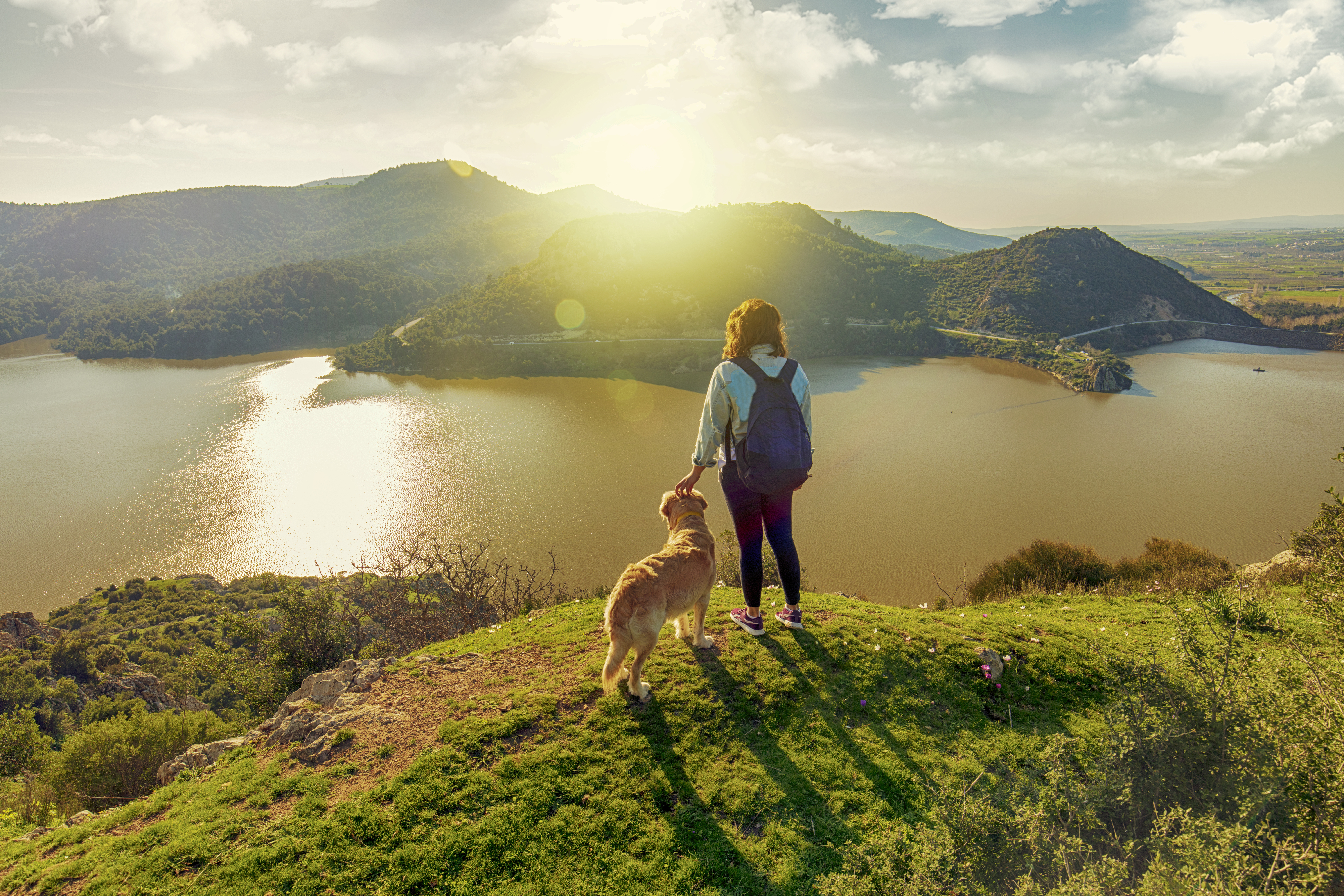 young woman trekking with the dog on mountains young woman trekking with the dog on mountains