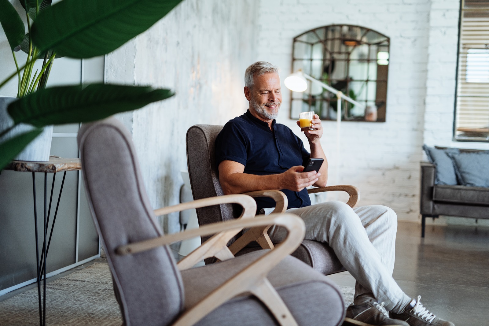 1455710373 Man in chair drinking orange juice