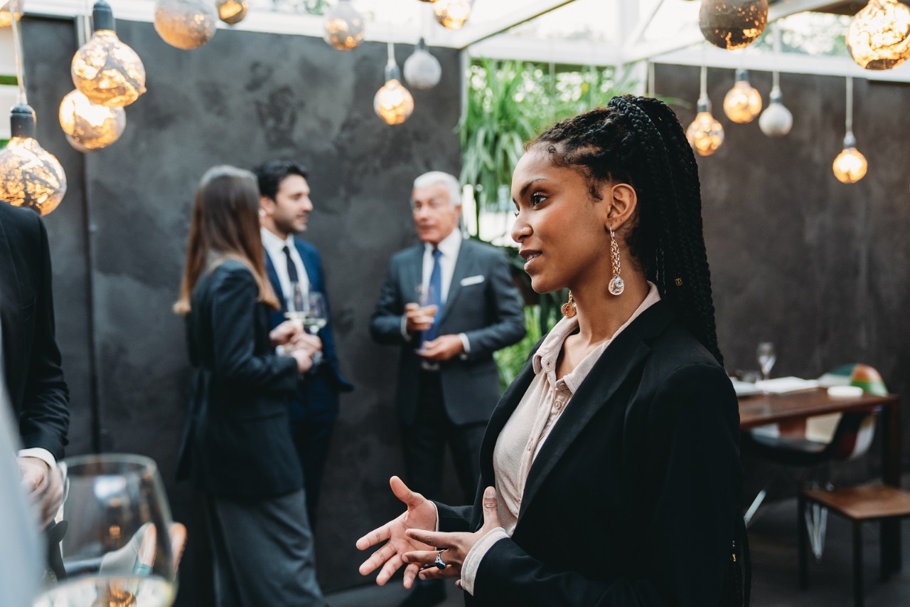Elegant people are talking together in an high-end restaurant during the aperitif. Business meeting outside the office.