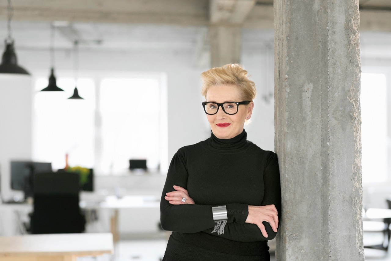 Portrait of elegant senior businesswoman standing in the modern studio, smiling at the camera.
